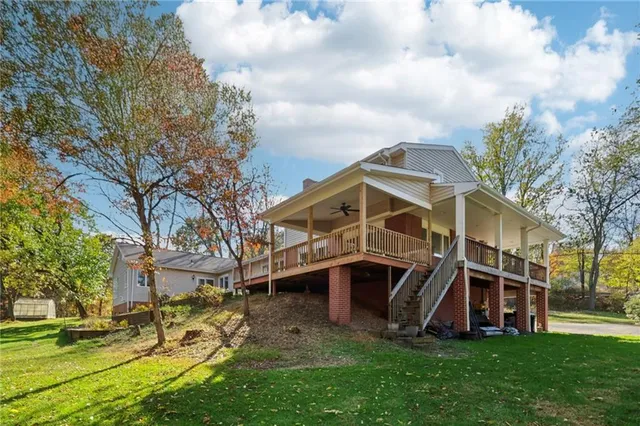 a front view of a house with a big yard and large trees