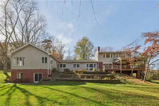 a view of a house with a big yard and large trees