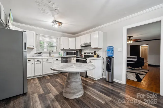a kitchen with a sink stainless steel appliances and white cabinets