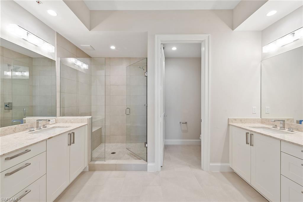 1111 Central Avenue, Unit 506 Naples, FL 34102 - Photo 11 of 21 a bathroom with a shower sink double vanity and mirror