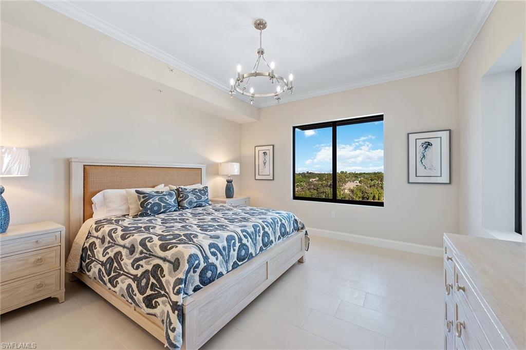 1111 Central Avenue, Unit 506 Naples, FL 34102 - Photo 10 of 21 a bedroom with a large bed and a chandelier