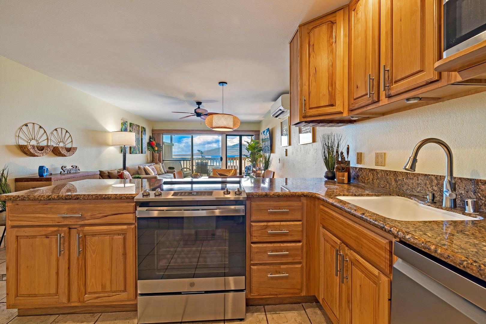 4909 Lower Honoapiilani Road, Unit E5 Lahaina, HI 96761 - Photo 18 of 28 a kitchen with granite countertop a sink and cabinets