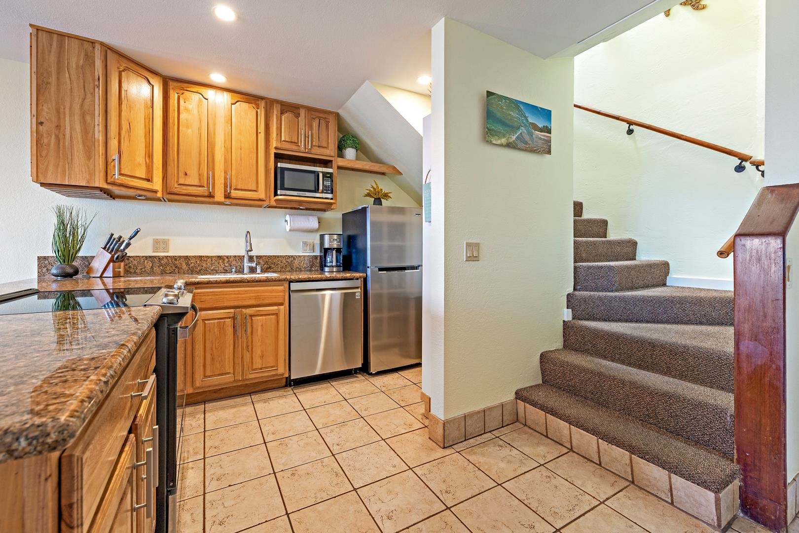 4909 Lower Honoapiilani Road, Unit E5 Lahaina, HI 96761 - Photo 19 of 28 a kitchen with stainless steel appliances a refrigerator and a stove top oven