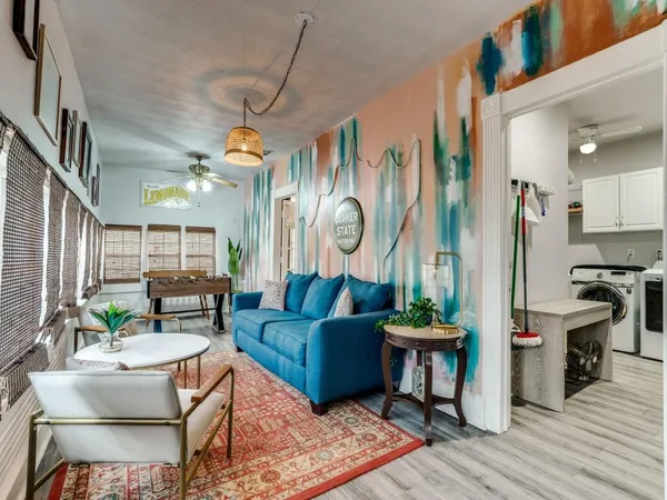 a living room with furniture a wooden floor and a chandelier