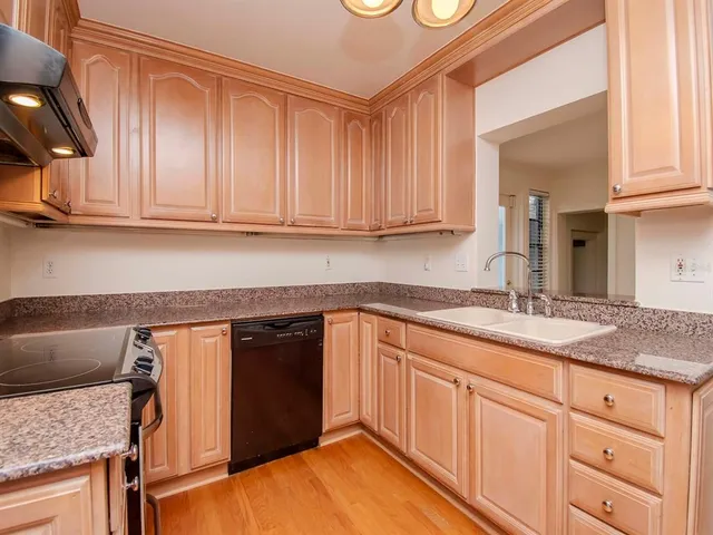 a kitchen with granite countertop a sink and cabinets