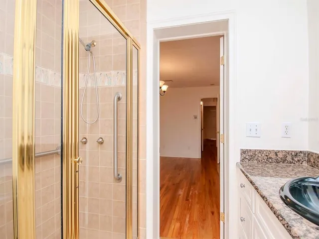 a view of bathroom with granite countertop shower and a sink
