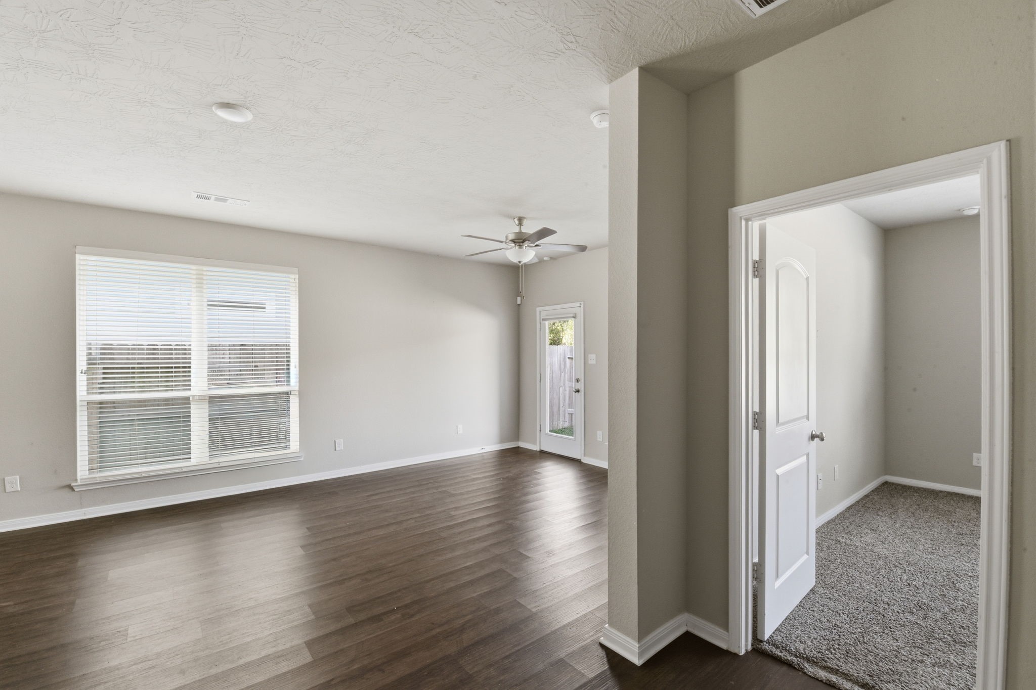 115 Austin Street Angleton, TX 77515 - Photo 4 of 33 an empty room with wooden floor cabinet and windows