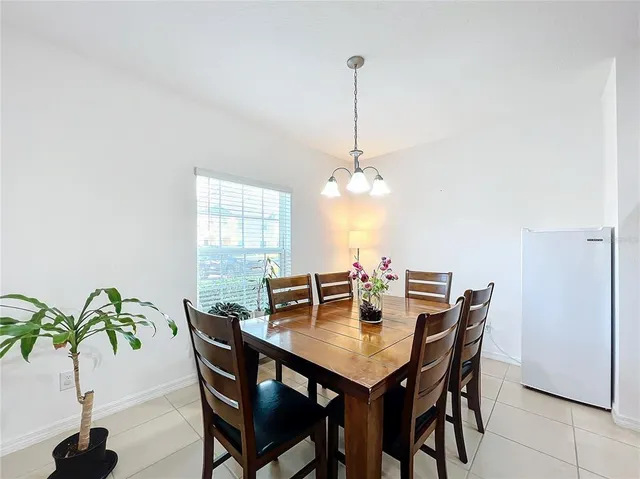 a view of a dining room and livingroom with furniture wooden floor a chandelier