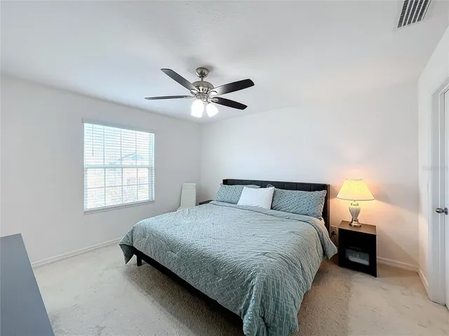 a bedroom with a bed and a ceiling fan