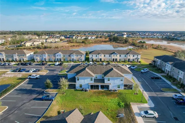 an aerial view of residential houses with outdoor space and ocean view
