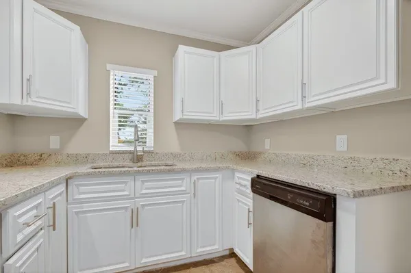 a kitchen with granite countertop white cabinets and a sink