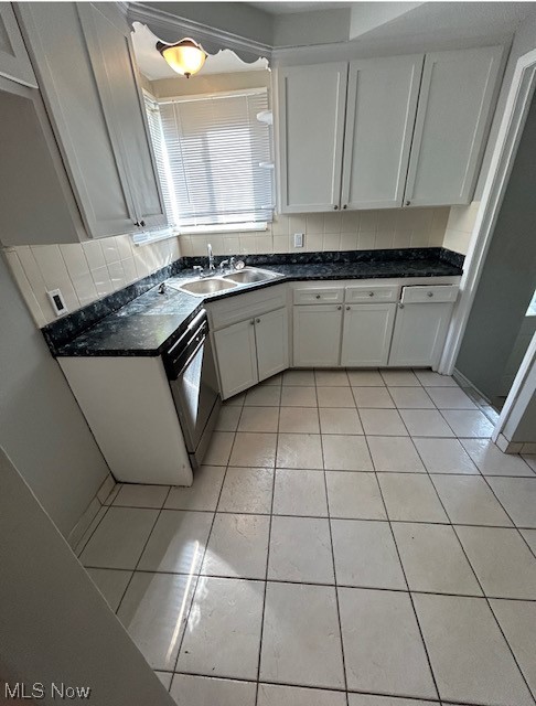 1287 Churchill Road Lyndhurst, OH 44124 - Photo 7 of 27 Kitchen with stainless steel dishwasher, sink, tasteful backsplash, white cabinetry, and light tile flooring