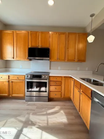 a kitchen with stainless steel appliances granite countertop a stove a sink and a microwave