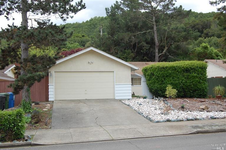 a view of a house with a yard and large tree