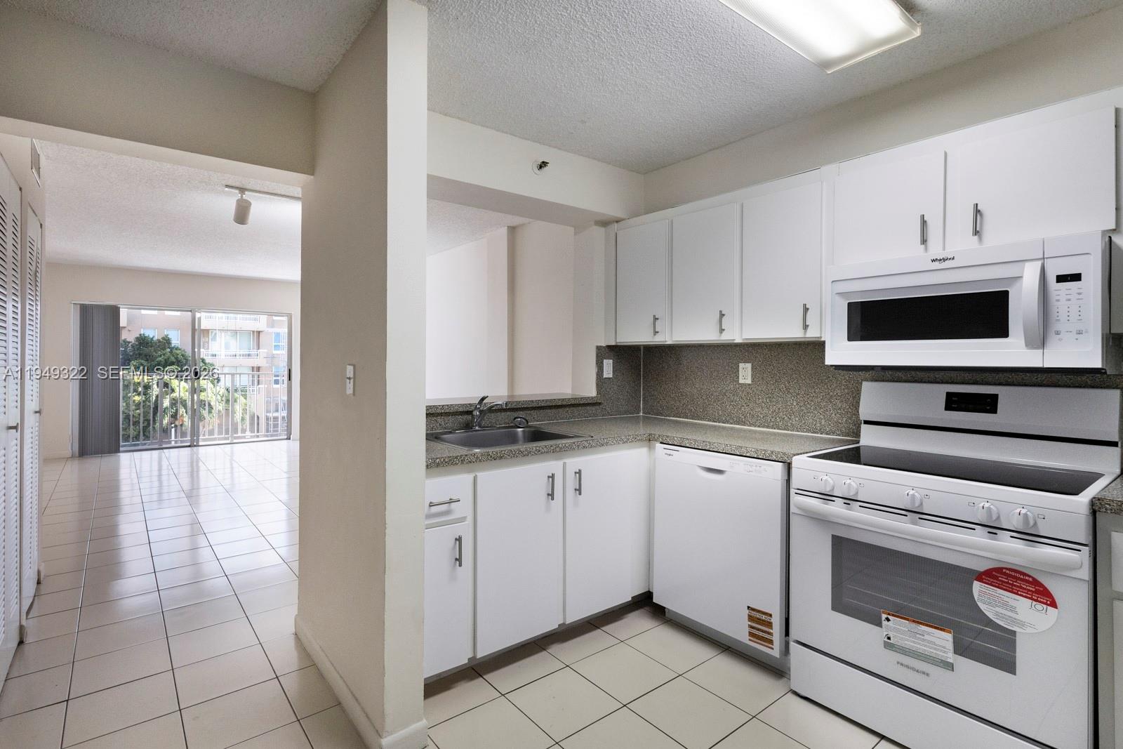 a kitchen with granite countertop a stove sink and cabinets