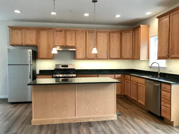 a kitchen with kitchen island granite countertop wooden cabinets and a sink