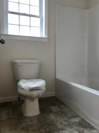 a white toilet sitting next to a window
