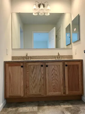 a bathroom with a granite countertop sink and a mirror
