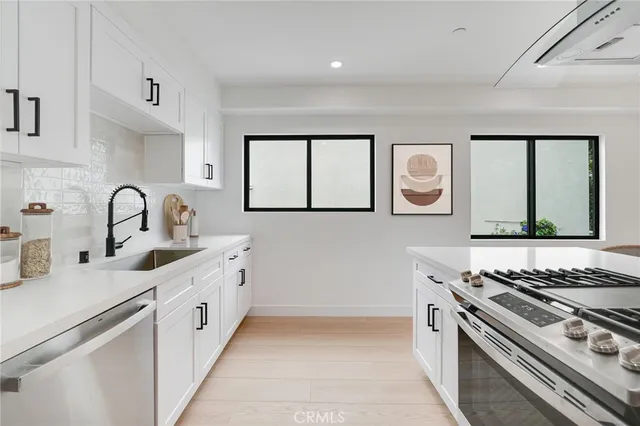 a kitchen with stainless steel appliances a sink and a stove