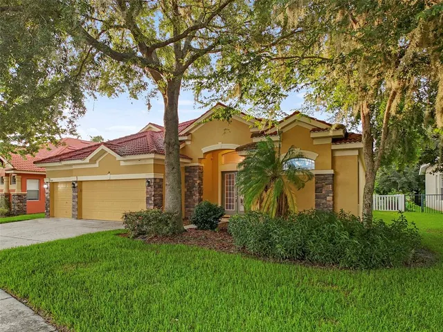 a front view of a house with a yard and trees