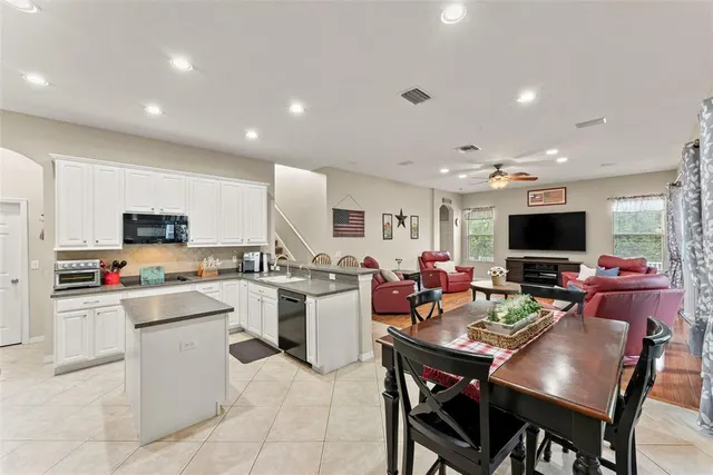 a living room with stainless steel appliances kitchen island granite countertop a dining table and chairs