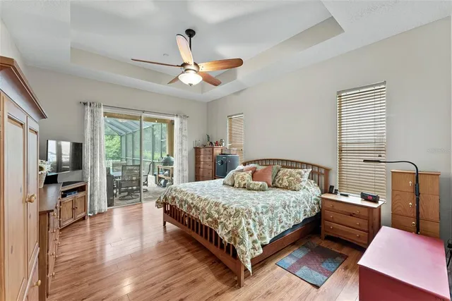 a bedroom with a large bed a flat tv screen and a dresser