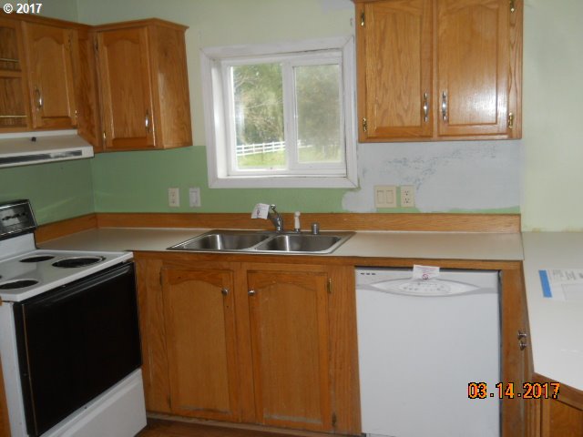 10045 South Prairie Road Tillamook, OR 97141 - Photo 12 of 24 a kitchen with a sink stove and cabinets