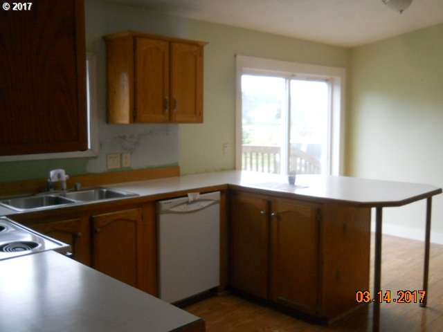 10045 South Prairie Road Tillamook, OR 97141 - Photo 13 of 24 a kitchen with a sink a window and cabinets