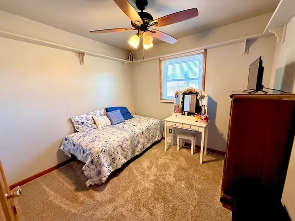 a bedroom with a bed and a table with potted plants