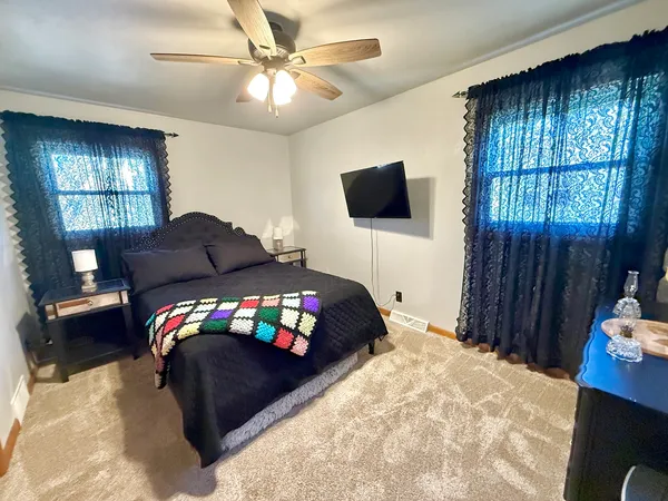 a bedroom with a bed window and a flat screen tv