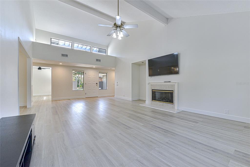 5355 Cobblestone Court Wesley Chapel, FL 33543 - Photo 19 of 54 a view of a livingroom with a fireplace a ceiling fan and wooden floor