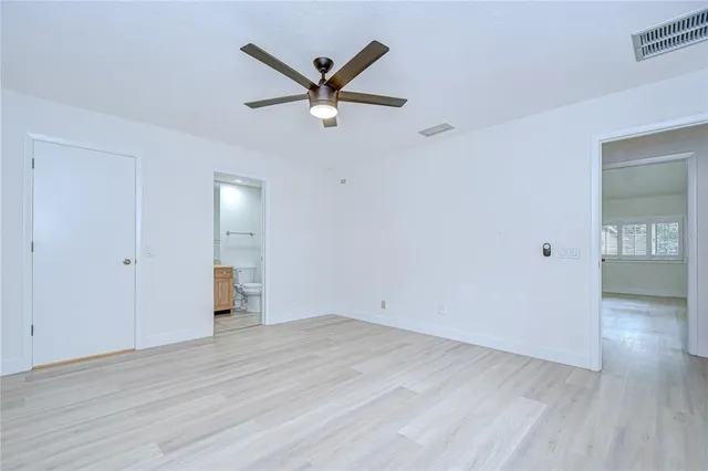 a view of a room with wooden floor and a ceiling fan
