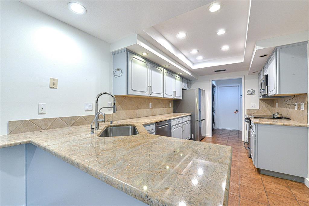 5355 Cobblestone Court Wesley Chapel, FL 33543 - Photo 26 of 54 a kitchen with stainless steel appliances granite countertop a sink a stove and a refrigerator