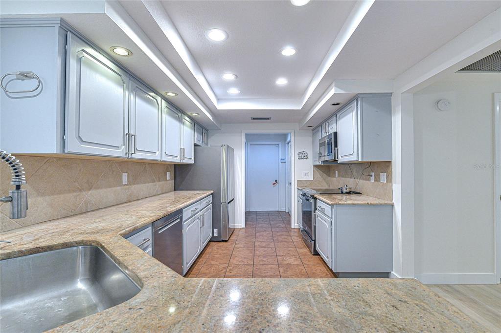 5355 Cobblestone Court Wesley Chapel, FL 33543 - Photo 28 of 54 a kitchen with stainless steel appliances granite countertop a sink stove and cabinets