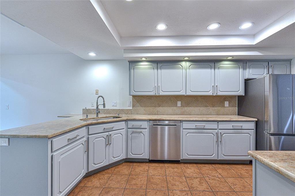 5355 Cobblestone Court Wesley Chapel, FL 33543 - Photo 29 of 54 a kitchen with a sink stove and cabinets