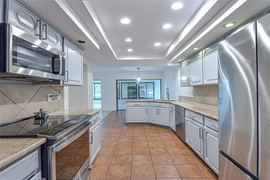 5355 Cobblestone Court Wesley Chapel, FL 33543 - Photo 30 of 54 a large kitchen with stainless steel appliances granite countertop a large stove top oven a sink dishwasher and cabinets