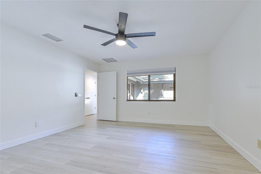 5355 Cobblestone Court Wesley Chapel, FL 33543 - Photo 47 of 54 a view of empty room with wooden floor and fan