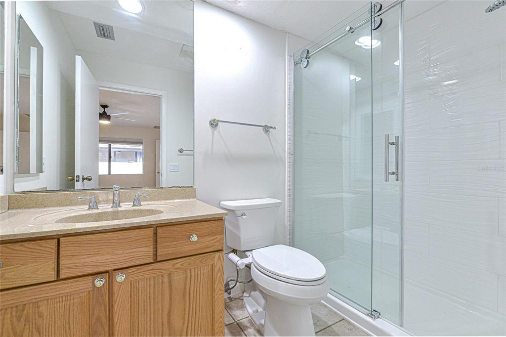 5355 Cobblestone Court Wesley Chapel, FL 33543 - Photo 50 of 59 a bathroom with a granite countertop sink toilet and shower