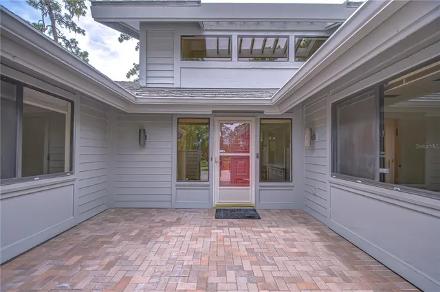 a view of a house with a yard and palm trees