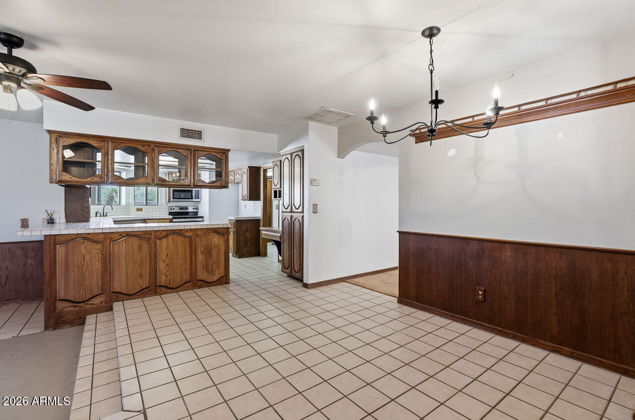1302 East Maddock Road Phoenix, AZ 85086 - Photo 8 of 40 a kitchen with stainless steel appliances kitchen island granite countertop a refrigerator and a stove top oven