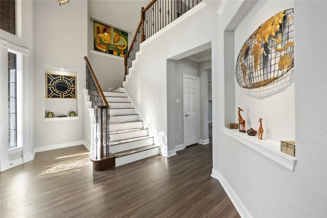 a view of a hallway with wooden floor and entryway