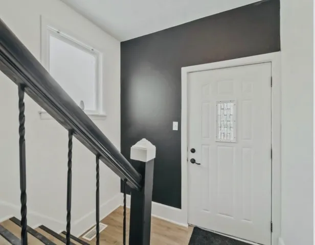 a view of staircase with railing and white walls