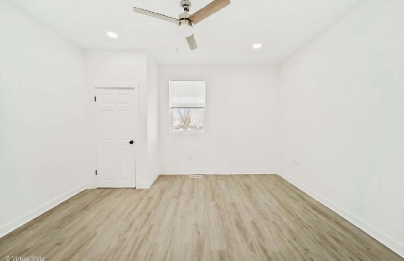 1216 Park Avenue, Unit 1 Chicago Heights, IL 60411 - Photo 5 of 10 an empty room with wooden floor and windows