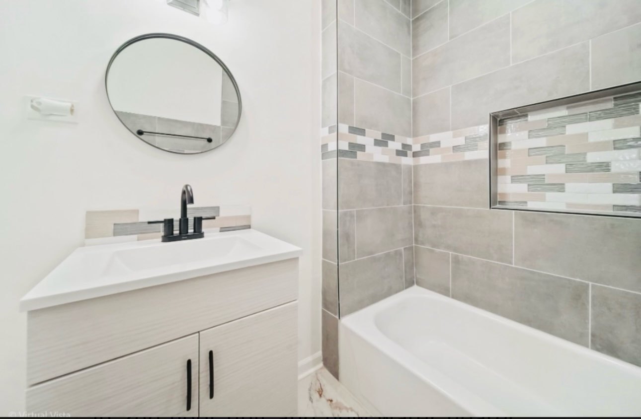1216 Park Avenue, Unit 1 Chicago Heights, IL 60411 - Photo 6 of 10 a bathroom with a sink a toilet and a mirror