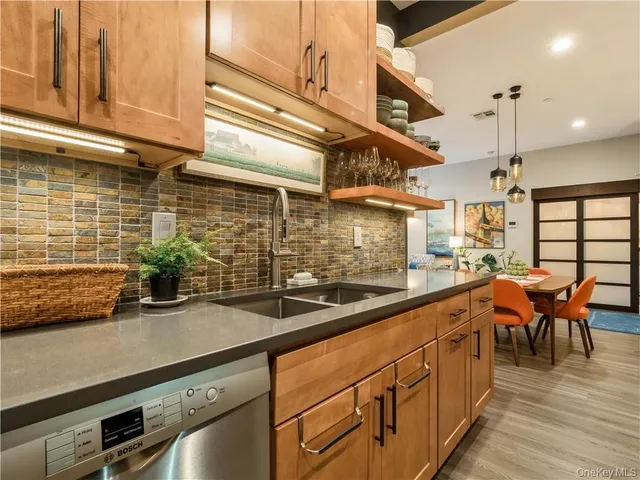 a kitchen with stainless steel appliances a sink a stove and a wooden floor