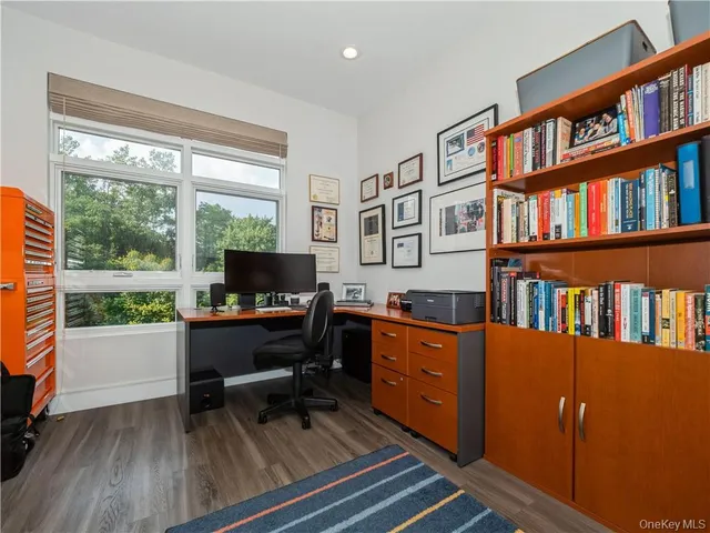a work room with furniture bookshelf and a window