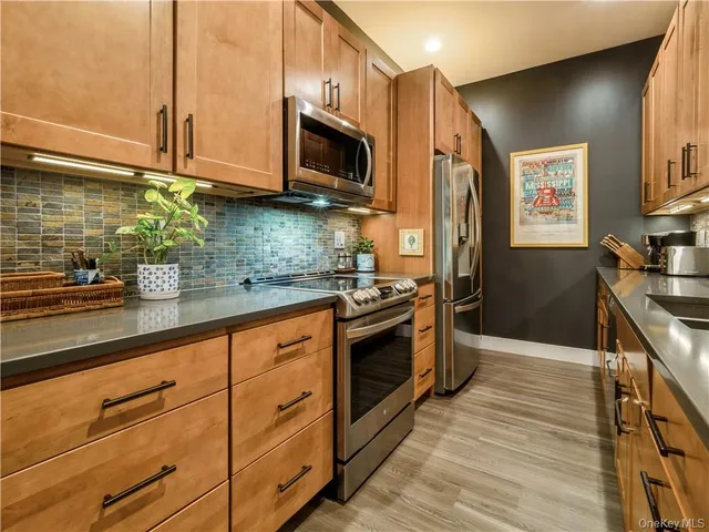 a kitchen with stainless steel appliances granite countertop a stove a sink and a microwave