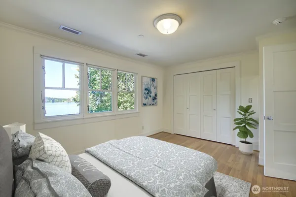 a bedroom with a bed and a potted plant
