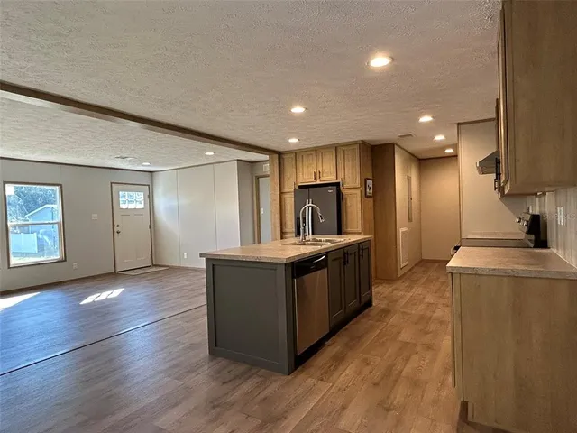 a sink with granite countertop cabinets