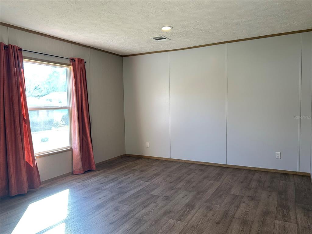 6443 Finance Avenue Weeki Wachee, FL 34607 - Photo 19 of 45 an empty room with wooden floor and windows